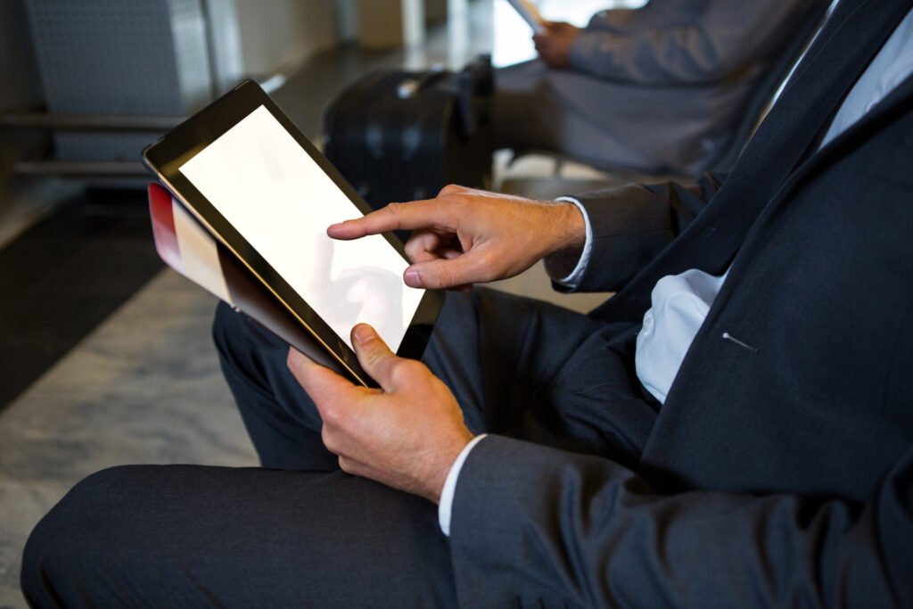 businessman using digital tablet while sitting airport terminal